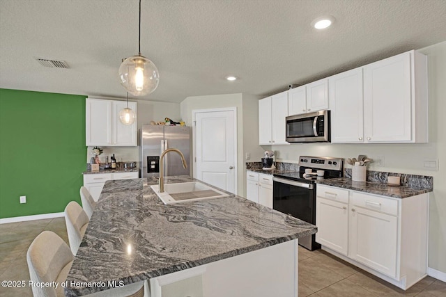 kitchen featuring white cabinetry, sink, a textured ceiling, and appliances with stainless steel finishes