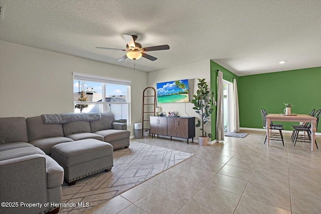 tiled living room with ceiling fan and a textured ceiling