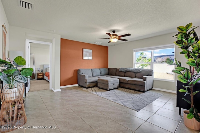 tiled living room featuring ceiling fan and a textured ceiling