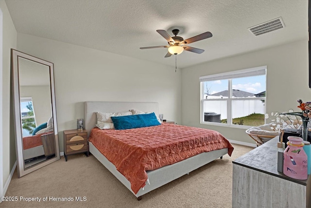 carpeted bedroom featuring a textured ceiling and ceiling fan