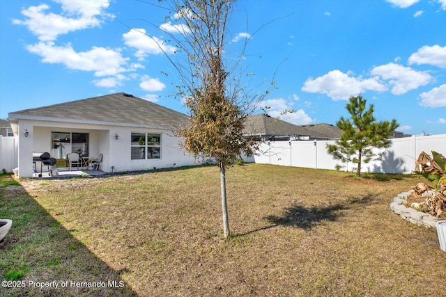 back of property with a lawn and a patio