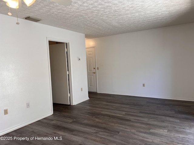 empty room featuring dark hardwood / wood-style floors and a textured ceiling