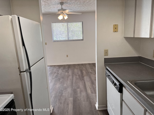 kitchen featuring hardwood / wood-style floors, sink, white appliances, ceiling fan, and a textured ceiling