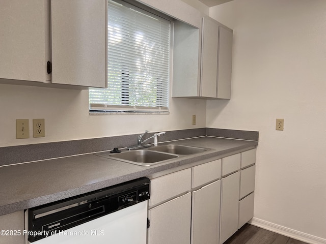 kitchen featuring dishwasher, sink, and dark wood-type flooring