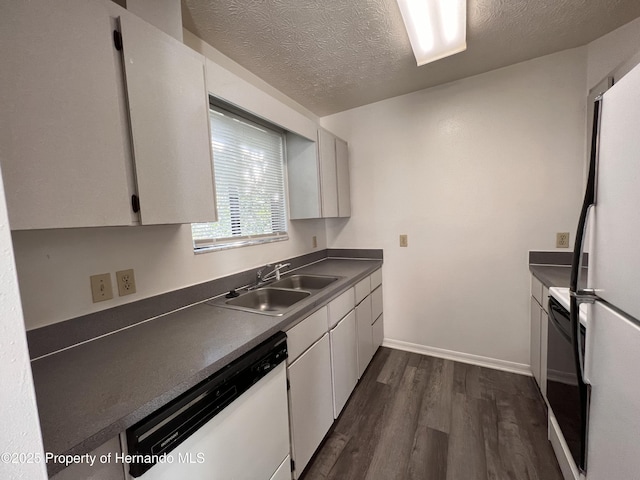 kitchen featuring white cabinetry, sink, white appliances, dark wood-type flooring, and a textured ceiling