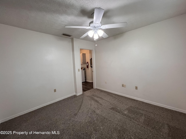 spare room with ceiling fan, a textured ceiling, and dark colored carpet