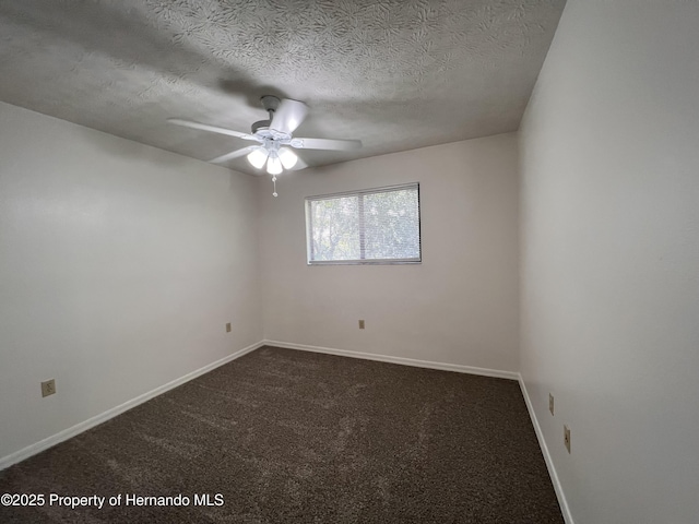 empty room with ceiling fan, dark carpet, and a textured ceiling