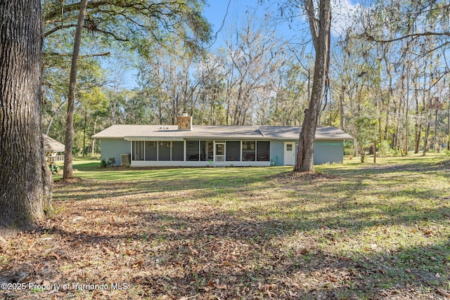 view of front of house with a front lawn and a sunroom