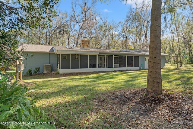 rear view of house featuring central AC, a lawn, and a sunroom