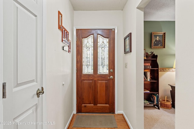 carpeted entryway with a textured ceiling