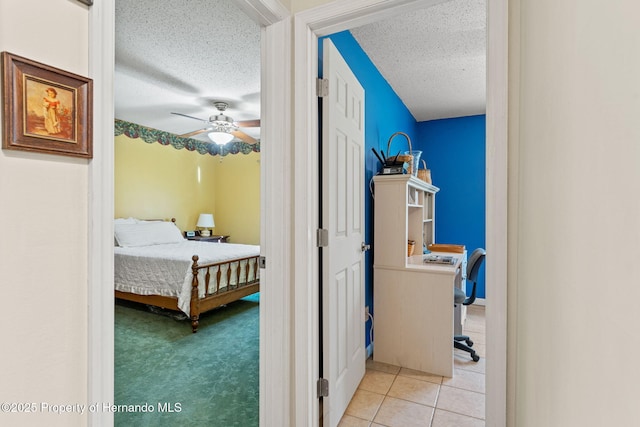 bedroom featuring ceiling fan, a textured ceiling, and light tile patterned floors