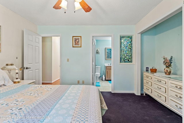 carpeted bedroom featuring ensuite bathroom, a textured ceiling, and ceiling fan