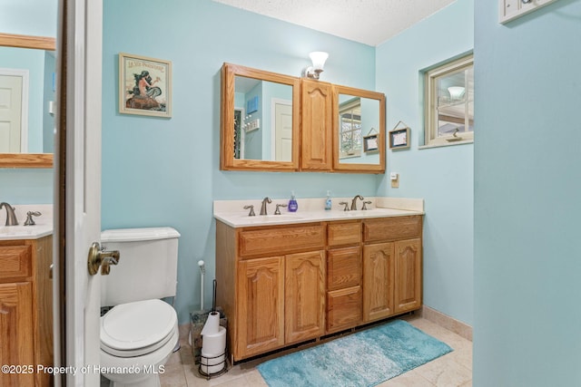 bathroom featuring toilet, a textured ceiling, tile patterned floors, and vanity