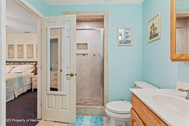 bathroom with toilet, vanity, a textured ceiling, and a shower with shower door