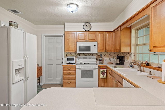 kitchen with white appliances, a textured ceiling, backsplash, and sink