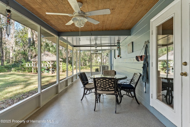 sunroom / solarium with ceiling fan and wood ceiling