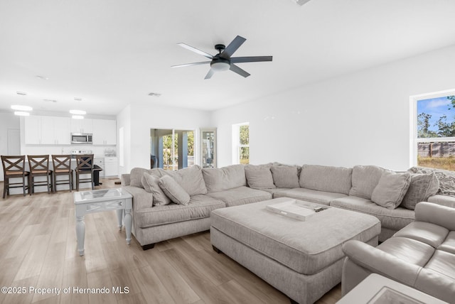 living room featuring ceiling fan and light wood-type flooring