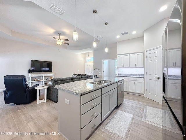 kitchen featuring ceiling fan, sink, pendant lighting, a kitchen island with sink, and appliances with stainless steel finishes