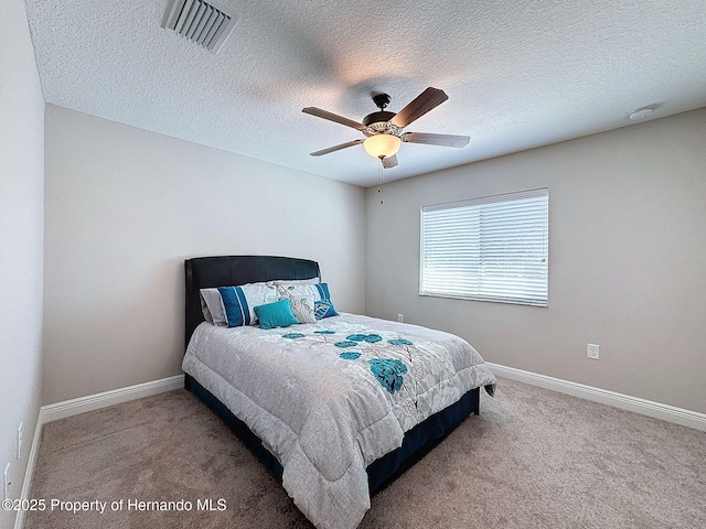 carpeted bedroom featuring a textured ceiling and ceiling fan