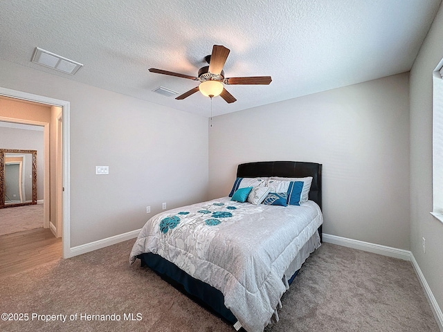 carpeted bedroom with a textured ceiling and ceiling fan