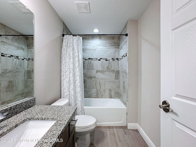 full bathroom with vanity, a textured ceiling, shower / bathtub combination with curtain, hardwood / wood-style floors, and toilet