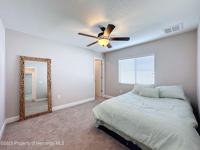 carpeted bedroom with ceiling fan and a textured ceiling