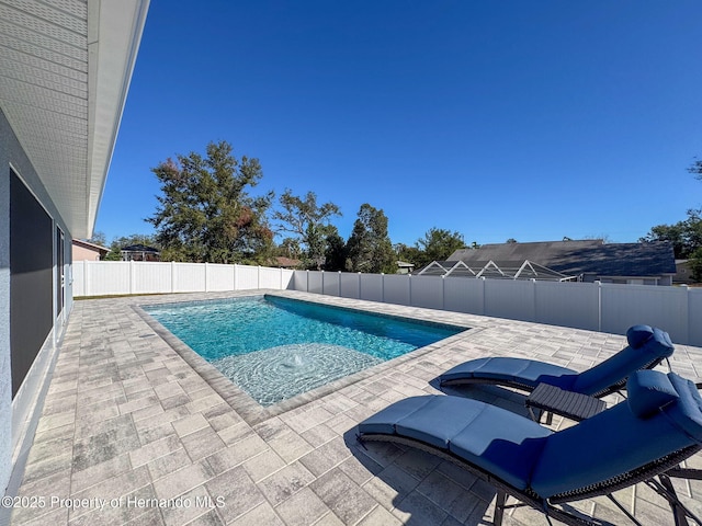 view of swimming pool with a patio and a hot tub