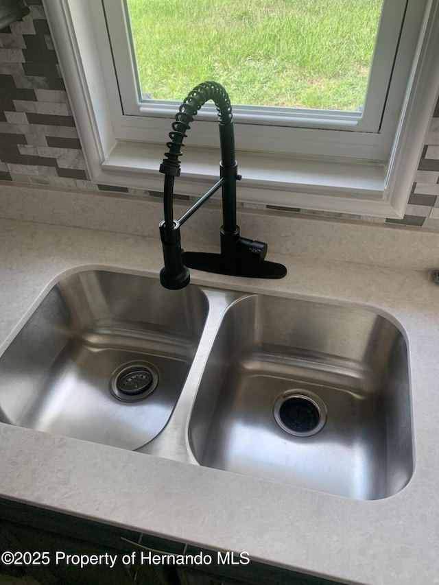 interior details featuring sink and tasteful backsplash