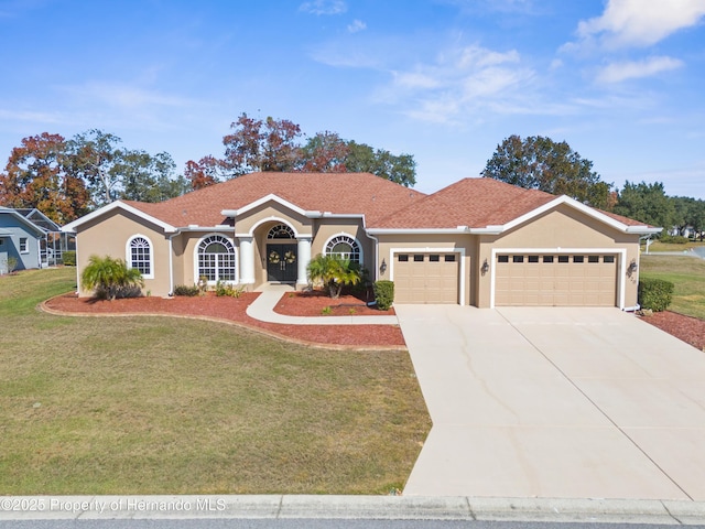 view of front of home with a garage and a front lawn