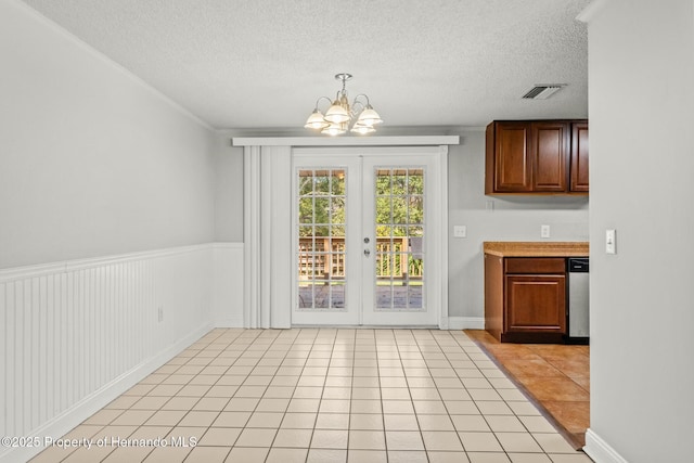 unfurnished dining area featuring light tile patterned floors, a notable chandelier, french doors, and a textured ceiling