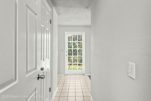 entryway with light tile patterned flooring and a textured ceiling