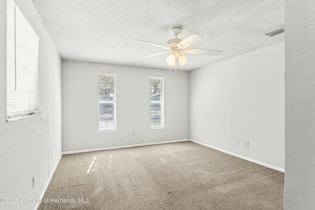 carpeted empty room featuring ceiling fan and a textured ceiling