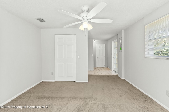 unfurnished bedroom with light colored carpet and ceiling fan