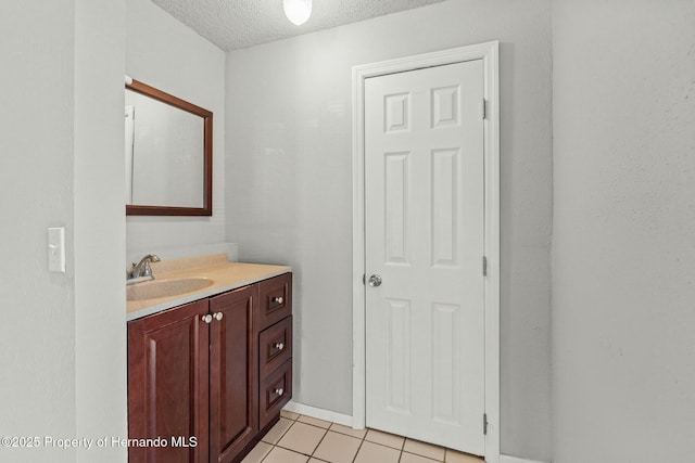 bathroom with tile patterned floors, a textured ceiling, and vanity