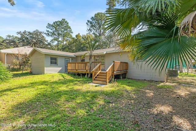 back of house featuring a wooden deck and a lawn