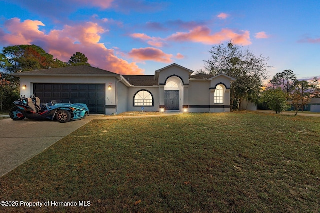 view of front of property featuring a lawn and a garage