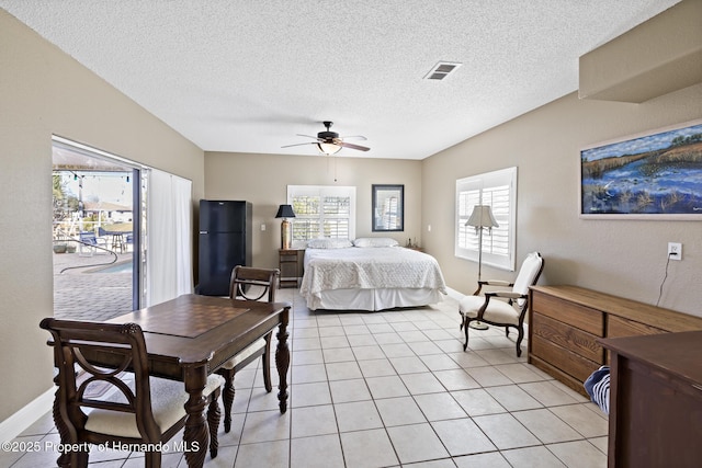 tiled bedroom with ceiling fan, black refrigerator, multiple windows, and access to outside