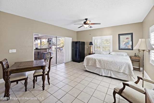 bedroom with black refrigerator, multiple windows, ceiling fan, and access to outside