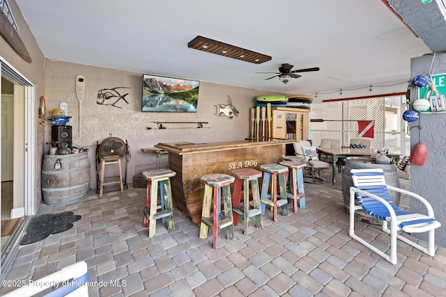 view of patio featuring ceiling fan and an outdoor bar