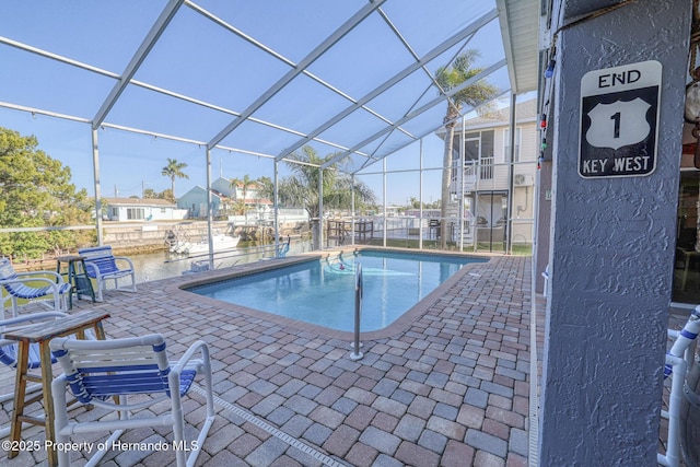 view of swimming pool with a patio area and a lanai