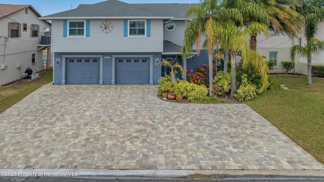 view of front of home featuring a garage and central AC