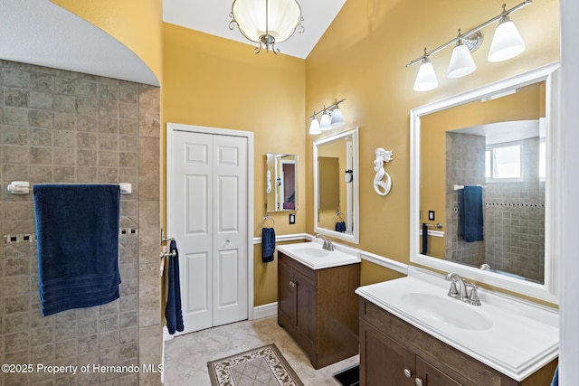 bathroom featuring vanity, vaulted ceiling, and tile patterned floors