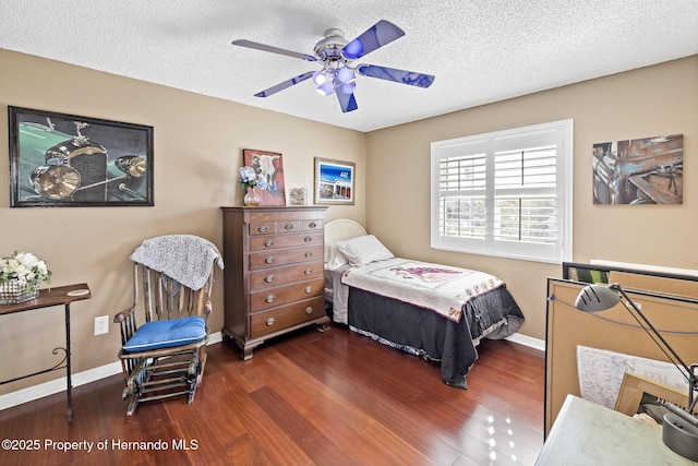 bedroom featuring ceiling fan, a textured ceiling, and dark hardwood / wood-style flooring