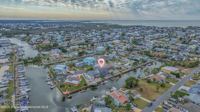 aerial view at dusk featuring a water view