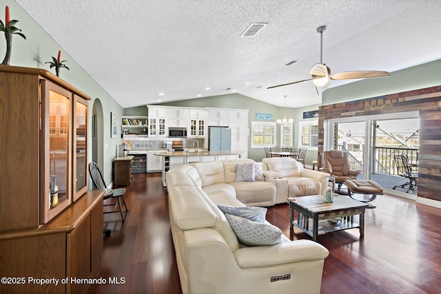 living room with vaulted ceiling, ceiling fan, dark hardwood / wood-style flooring, sink, and a textured ceiling