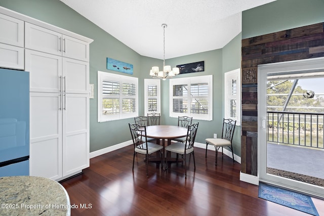 dining space featuring a textured ceiling, a notable chandelier, lofted ceiling, and dark hardwood / wood-style flooring