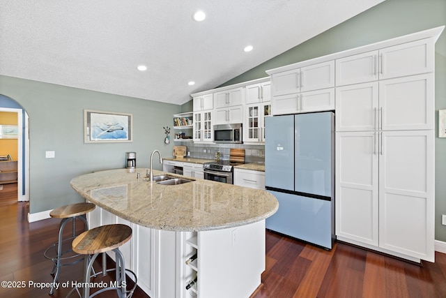 kitchen featuring sink, white cabinets, appliances with stainless steel finishes, and a center island with sink