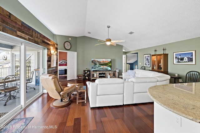 living room with a textured ceiling, dark hardwood / wood-style floors, vaulted ceiling, and ceiling fan