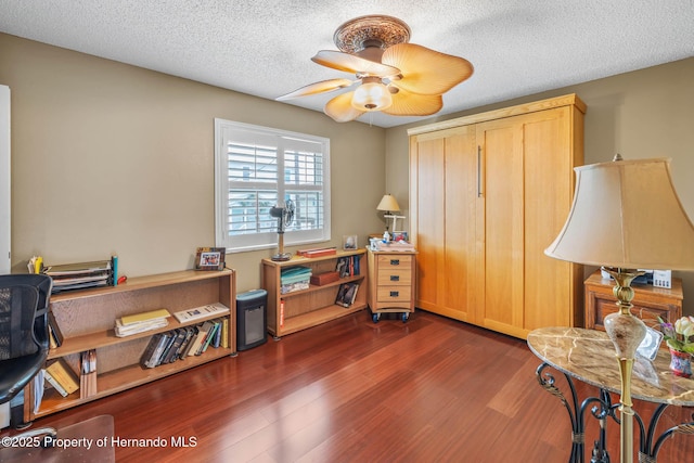 office featuring ceiling fan, dark wood-type flooring, and a textured ceiling