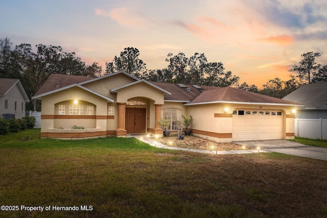 ranch-style home with a lawn and a garage